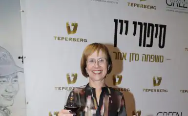 שרה טפרברג מחזיקה גביע יין לוגו טפרברג