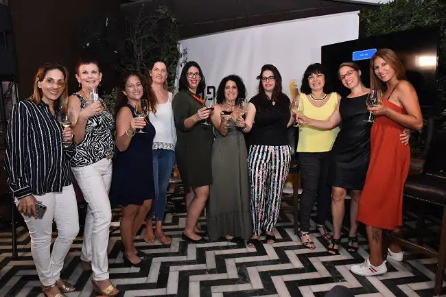 בנות מחזיקות כוס יין