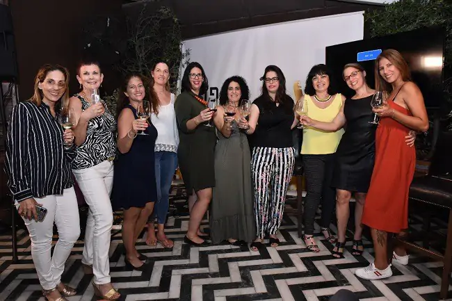 בנות מחזיקות כוס יין